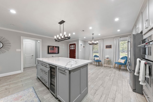 kitchen featuring gray cabinetry, light hardwood / wood-style floors, a center island, and decorative light fixtures