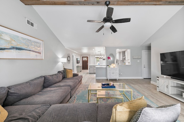 living room featuring light hardwood / wood-style floors, high vaulted ceiling, beamed ceiling, and ceiling fan with notable chandelier