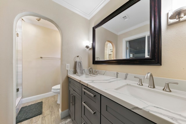 bathroom with hardwood / wood-style floors, toilet, a shower, vanity, and ornamental molding