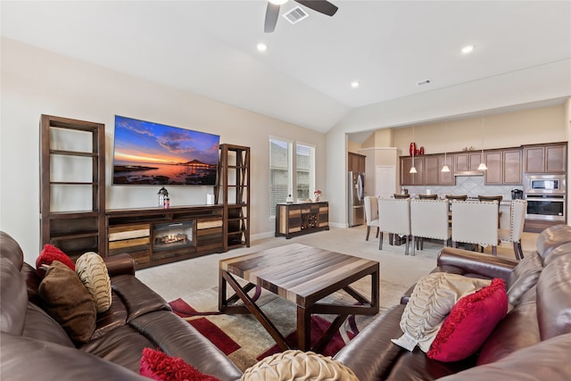 carpeted living room featuring vaulted ceiling and ceiling fan