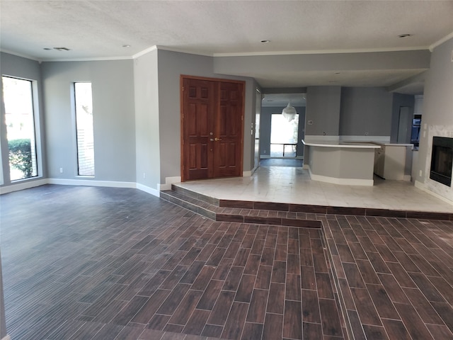 unfurnished living room featuring a textured ceiling and ornamental molding