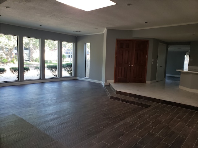 empty room with ornamental molding, a textured ceiling, and dark hardwood / wood-style floors