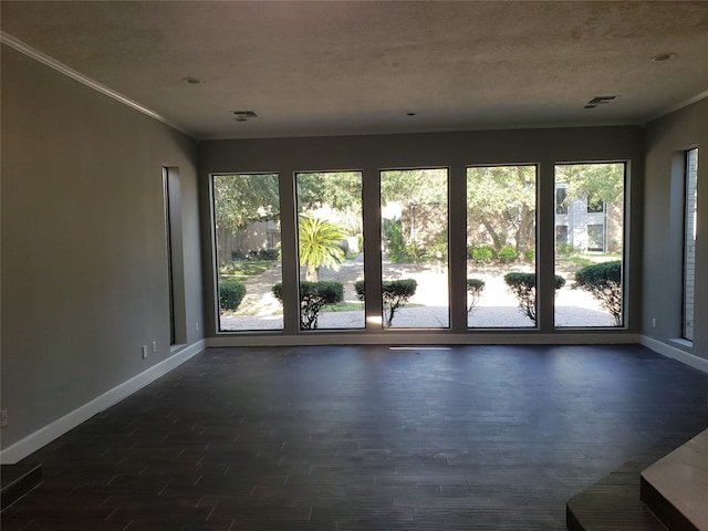 spare room with a textured ceiling, dark hardwood / wood-style floors, and crown molding