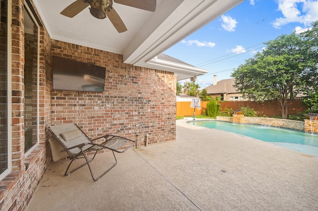 view of swimming pool featuring ceiling fan, pool water feature, and a patio area