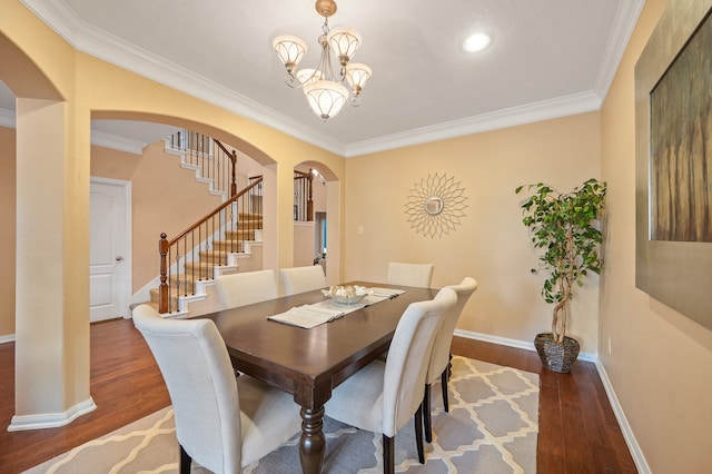 dining space featuring crown molding, dark hardwood / wood-style flooring, and a chandelier