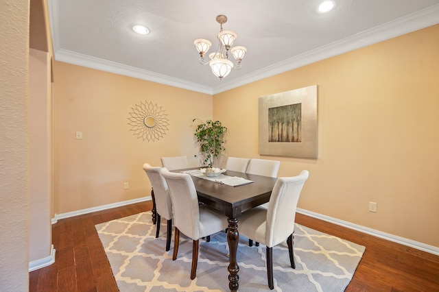 dining space featuring ornamental molding, a chandelier, and dark hardwood / wood-style flooring