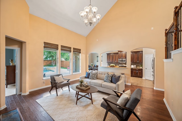 living room featuring an inviting chandelier, high vaulted ceiling, and hardwood / wood-style flooring