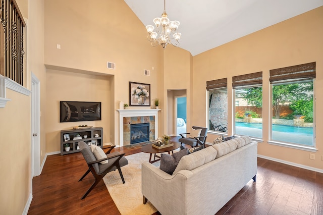 living room with high vaulted ceiling, a chandelier, a tile fireplace, and dark hardwood / wood-style floors