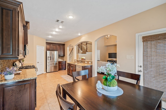 dining space with light tile patterned floors, a textured ceiling, and sink