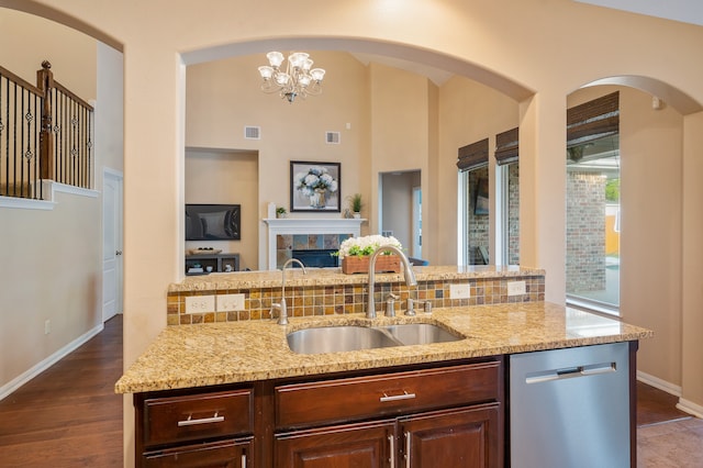 kitchen featuring dark brown cabinetry, sink, stainless steel dishwasher, a chandelier, and dark hardwood / wood-style flooring