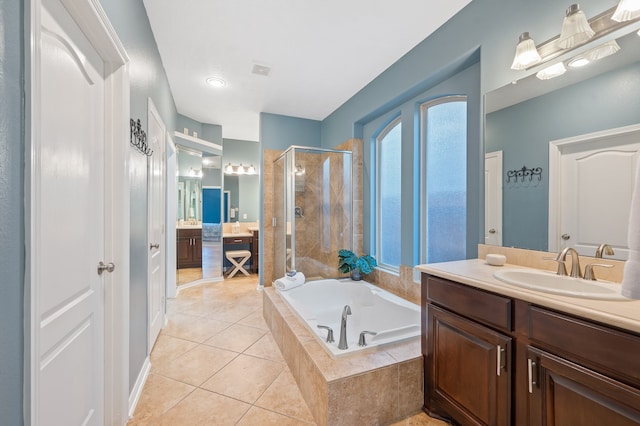 bathroom featuring independent shower and bath, vanity, and tile patterned floors