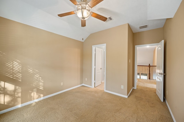 unfurnished bedroom featuring light carpet, lofted ceiling, and ceiling fan