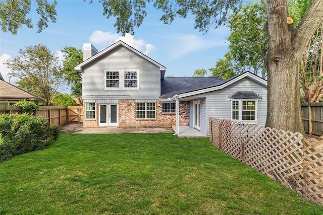 rear view of house featuring a lawn and a patio