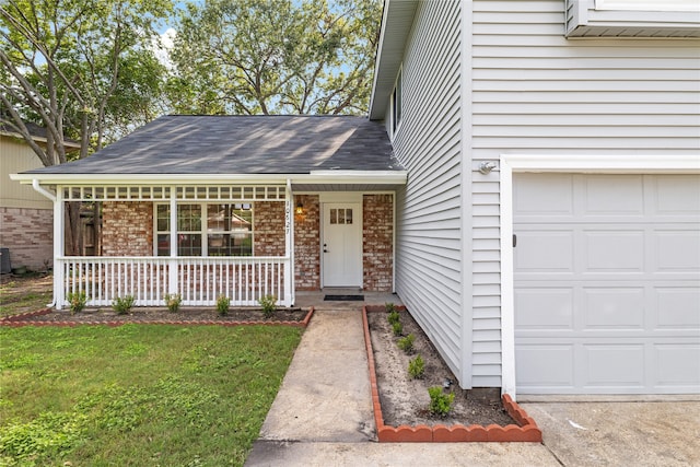 entrance to property with cooling unit, a yard, a porch, and a garage