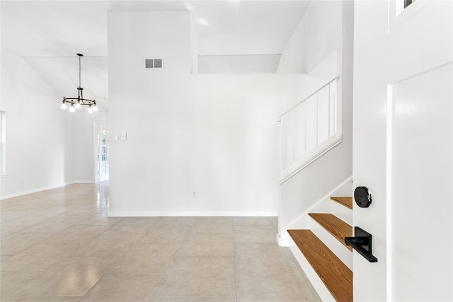 staircase featuring high vaulted ceiling, tile patterned flooring, and an inviting chandelier