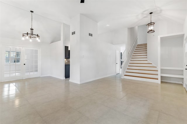 unfurnished living room with a notable chandelier, light tile patterned flooring, french doors, and high vaulted ceiling