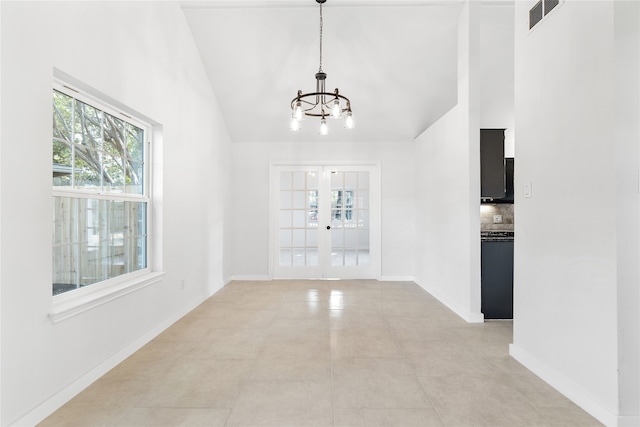 unfurnished dining area with french doors, a notable chandelier, and light tile patterned floors