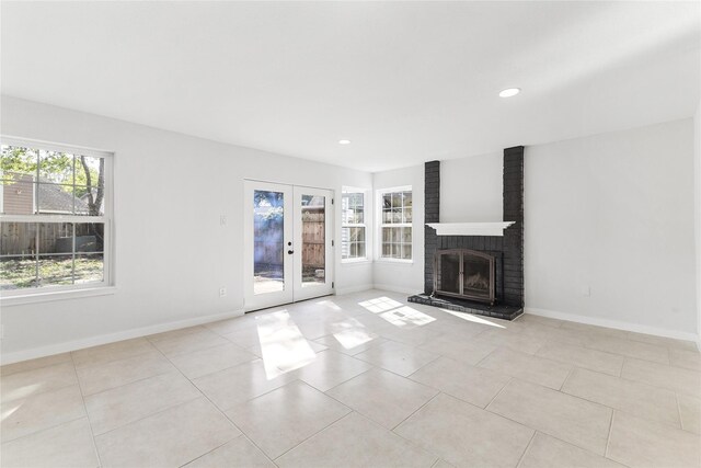 unfurnished living room with french doors, light tile patterned flooring, and a fireplace