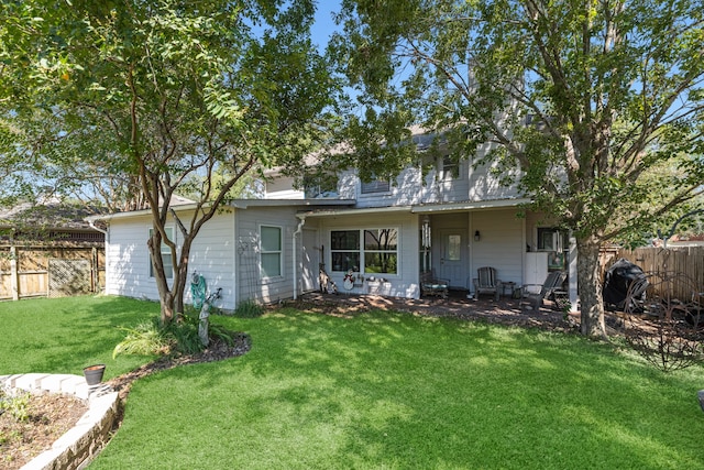 rear view of house featuring a lawn