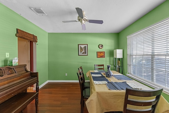 dining space featuring ceiling fan, a textured ceiling, and dark hardwood / wood-style floors