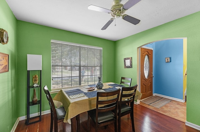 dining space featuring ceiling fan and dark wood-type flooring