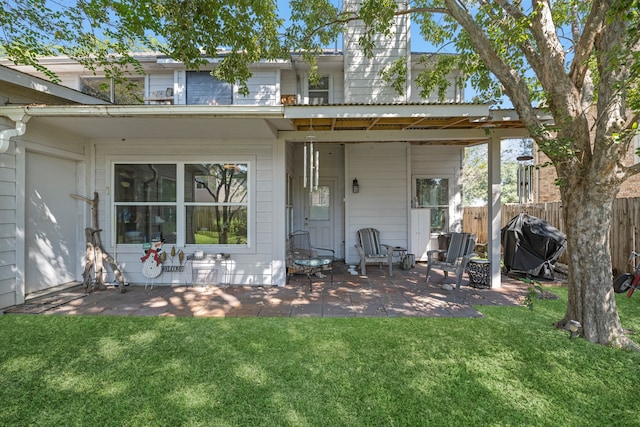 rear view of house featuring a patio area and a yard