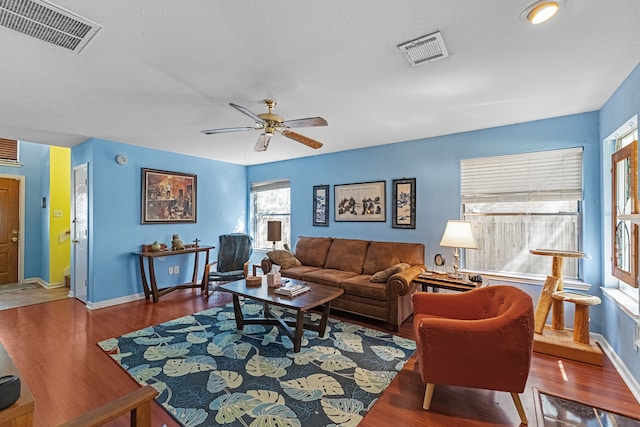 living room with ceiling fan and dark hardwood / wood-style flooring