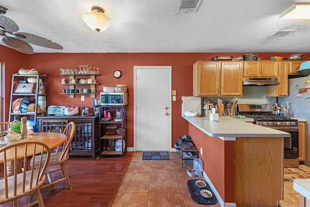 kitchen featuring range with gas cooktop, kitchen peninsula, dark hardwood / wood-style floors, and a textured ceiling