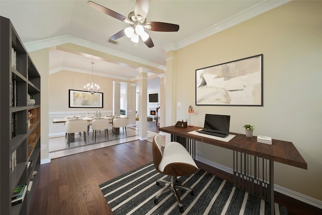 office area featuring vaulted ceiling, dark wood-type flooring, ceiling fan with notable chandelier, ornate columns, and ornamental molding