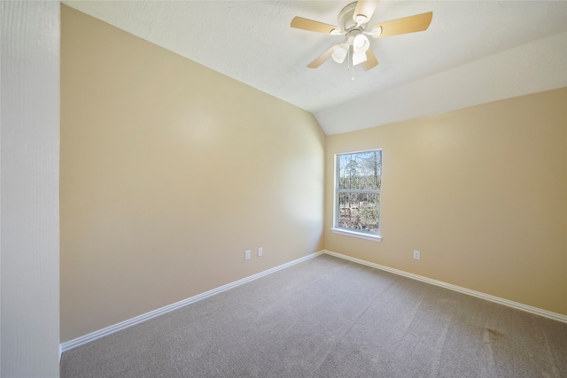 spare room featuring ceiling fan, carpet floors, and vaulted ceiling