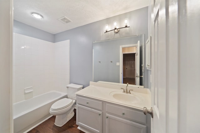 full bathroom with a textured ceiling, hardwood / wood-style floors, shower / bathing tub combination, vanity, and toilet