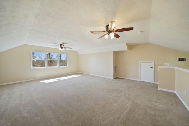 additional living space with light carpet, lofted ceiling, ceiling fan, and a textured ceiling