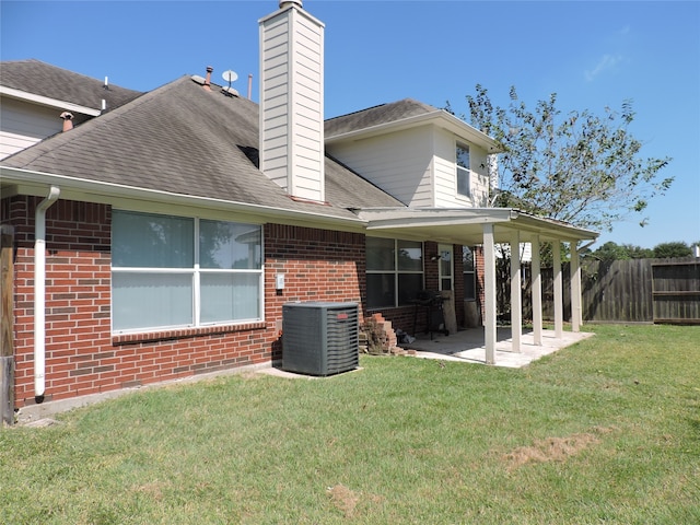 back of property with a patio, central air condition unit, and a yard