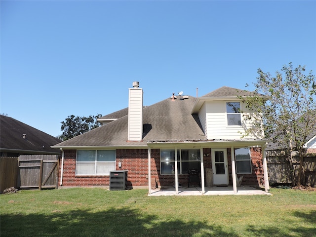 rear view of house with a patio, cooling unit, and a yard