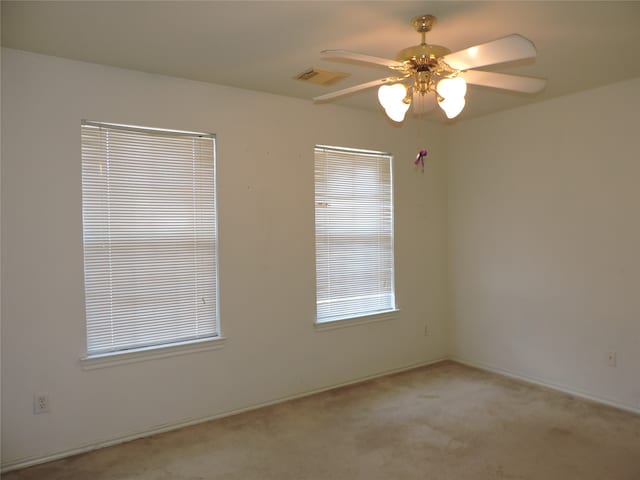 carpeted spare room with ceiling fan