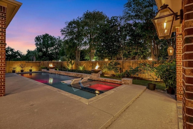 15026 Blossom Bay Dr, Houston, TX 77059 - pool at dusk featuring a fenced backyard, a fenced in pool, an in ground hot tub, and a patio area
