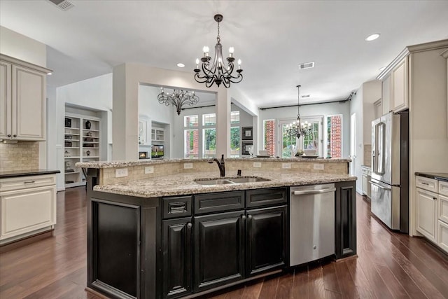 15026 Blossom Bay Dr, Houston, TX 77059 - kitchen featuring a sink, backsplash, a chandelier, dark cabinetry, and appliances with stainless steel finishes