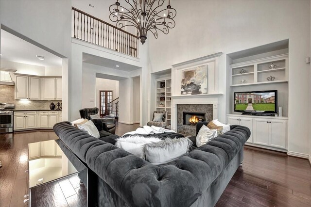 15026 Blossom Bay Dr, Houston, TX 77059 - living area featuring a chandelier, a fireplace, built in shelves, stairway, and dark wood-style floors