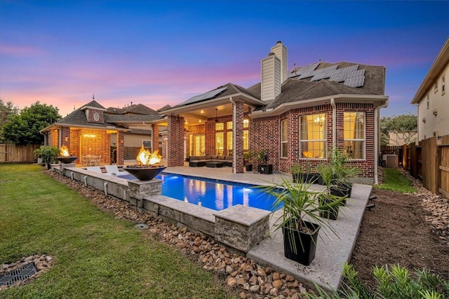 15026 Blossom Bay Dr, Houston, TX 77059 - rear view of property with brick siding, a fenced backyard, roof mounted solar panels, a patio, and a yard