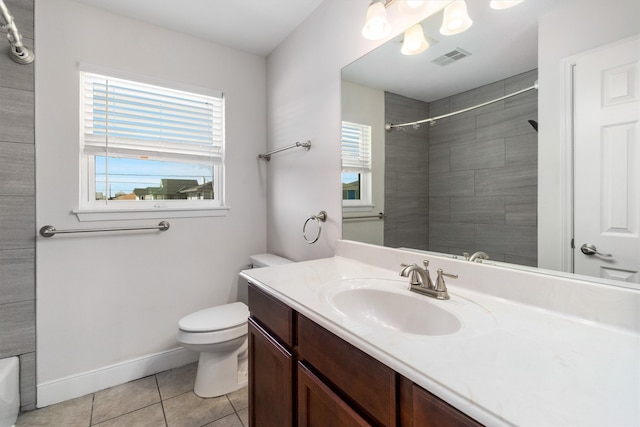 bathroom with tile patterned floors, tiled shower, vanity, and toilet