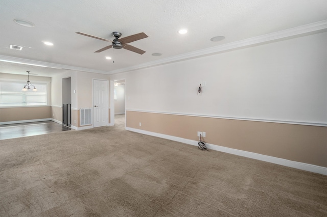 carpeted spare room with ceiling fan with notable chandelier and crown molding