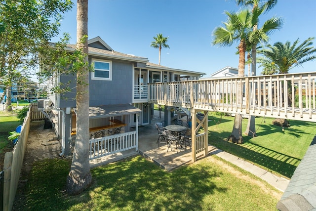 rear view of house featuring a lawn, a patio area, and a deck