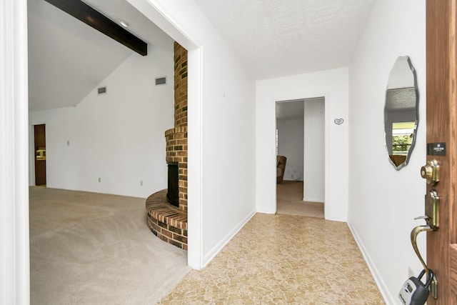 hallway with light carpet, lofted ceiling with beams, and a textured ceiling