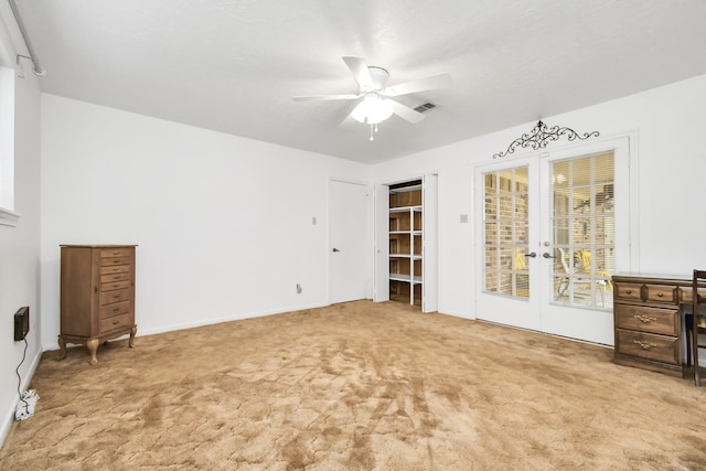 unfurnished bedroom featuring access to exterior, ceiling fan, and light colored carpet