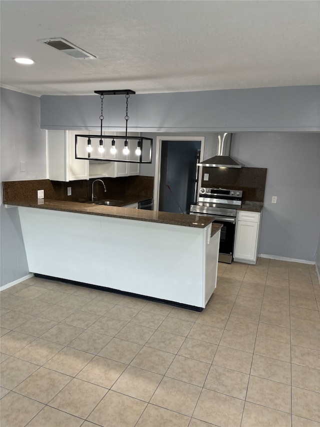 kitchen featuring hanging light fixtures, kitchen peninsula, wall chimney exhaust hood, white cabinetry, and stainless steel electric range oven