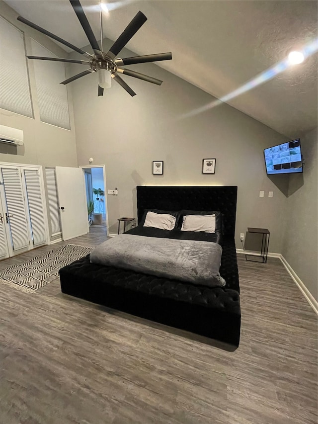 bedroom featuring ceiling fan, lofted ceiling, hardwood / wood-style floors, and a wall mounted AC