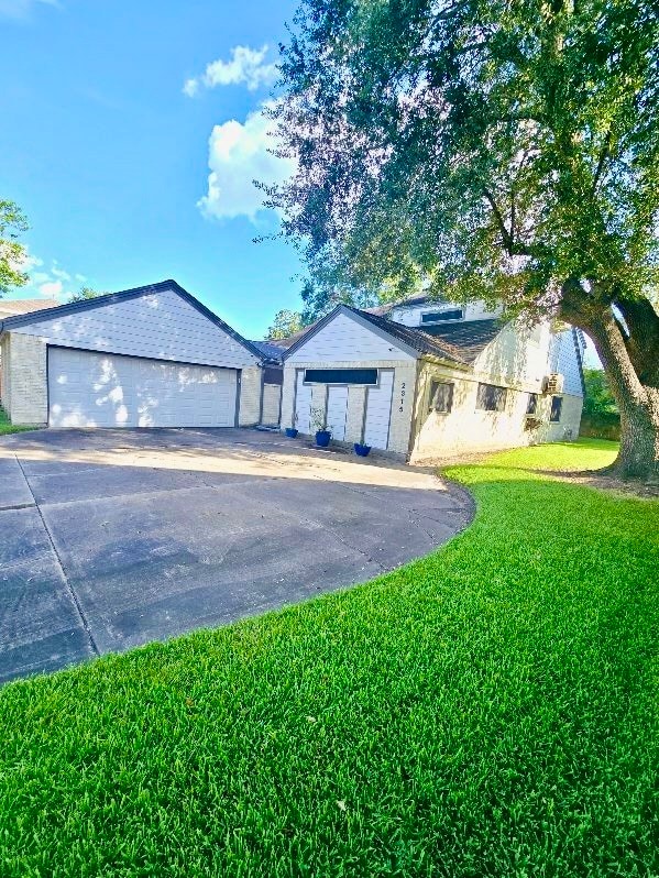 ranch-style house featuring a front lawn and a garage