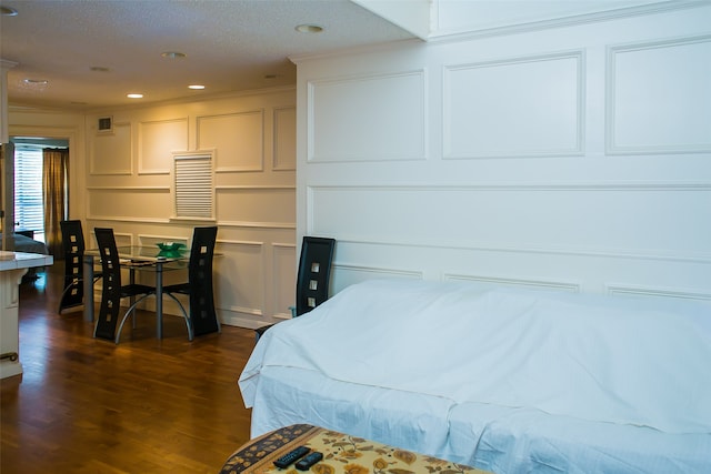 bedroom featuring a textured ceiling, dark hardwood / wood-style floors, and crown molding