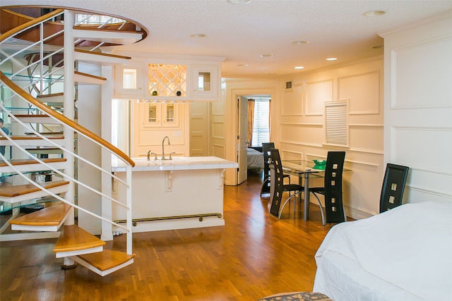 interior space with a textured ceiling, dark hardwood / wood-style floors, sink, and crown molding