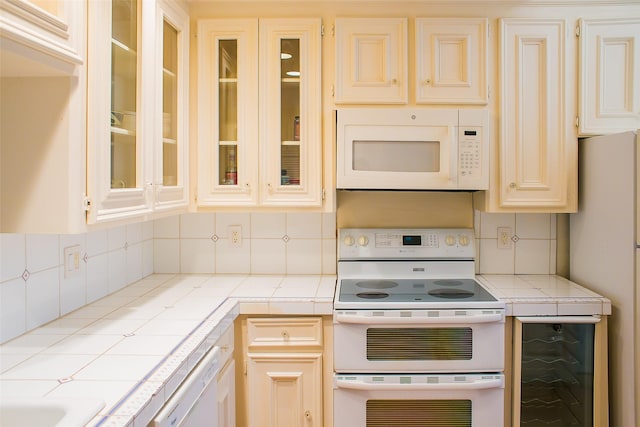 8235 Sands Point Dr Unit 156, Houston, TX 77036 - kitchen with white appliances, tile countertops, tasteful backsplash, and glass insert cabinets